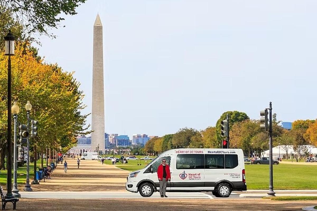 Un hombre parado frente a una camioneta frente al monumento a Washington.