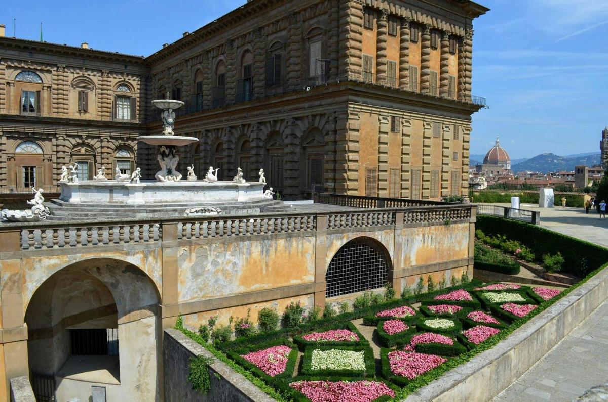 un edifici amb una font i flors en un jardí