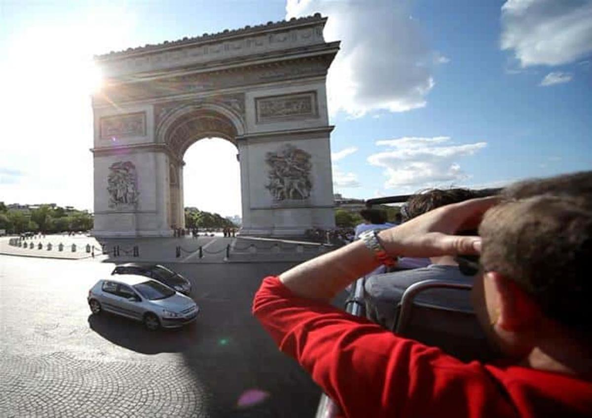 un uomo che guarda un'auto davanti all'arco