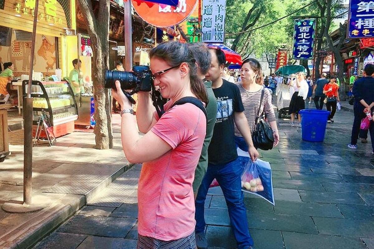 一名女子在街上用相机拍照