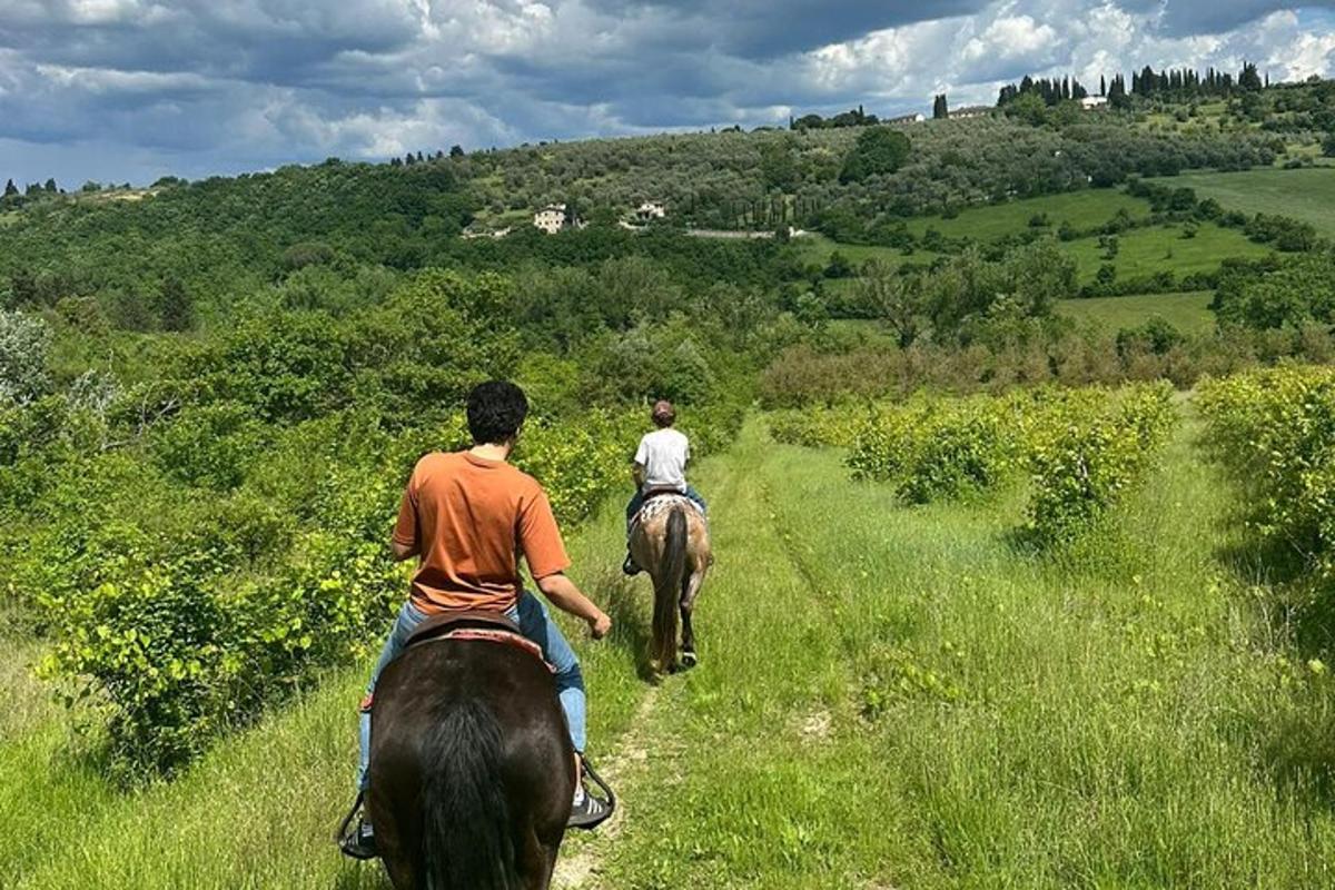 duas pessoas cavalgando em um campo