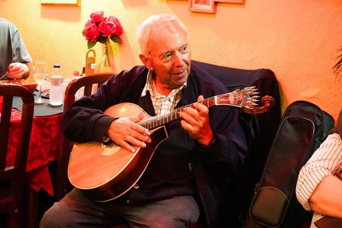 seorang lelaki duduk di kerusi bermain gitar