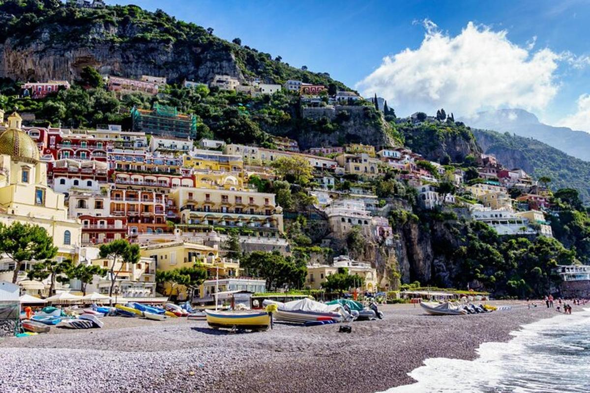 un gruppo di barche sulla spiaggia di fronte a una montagna