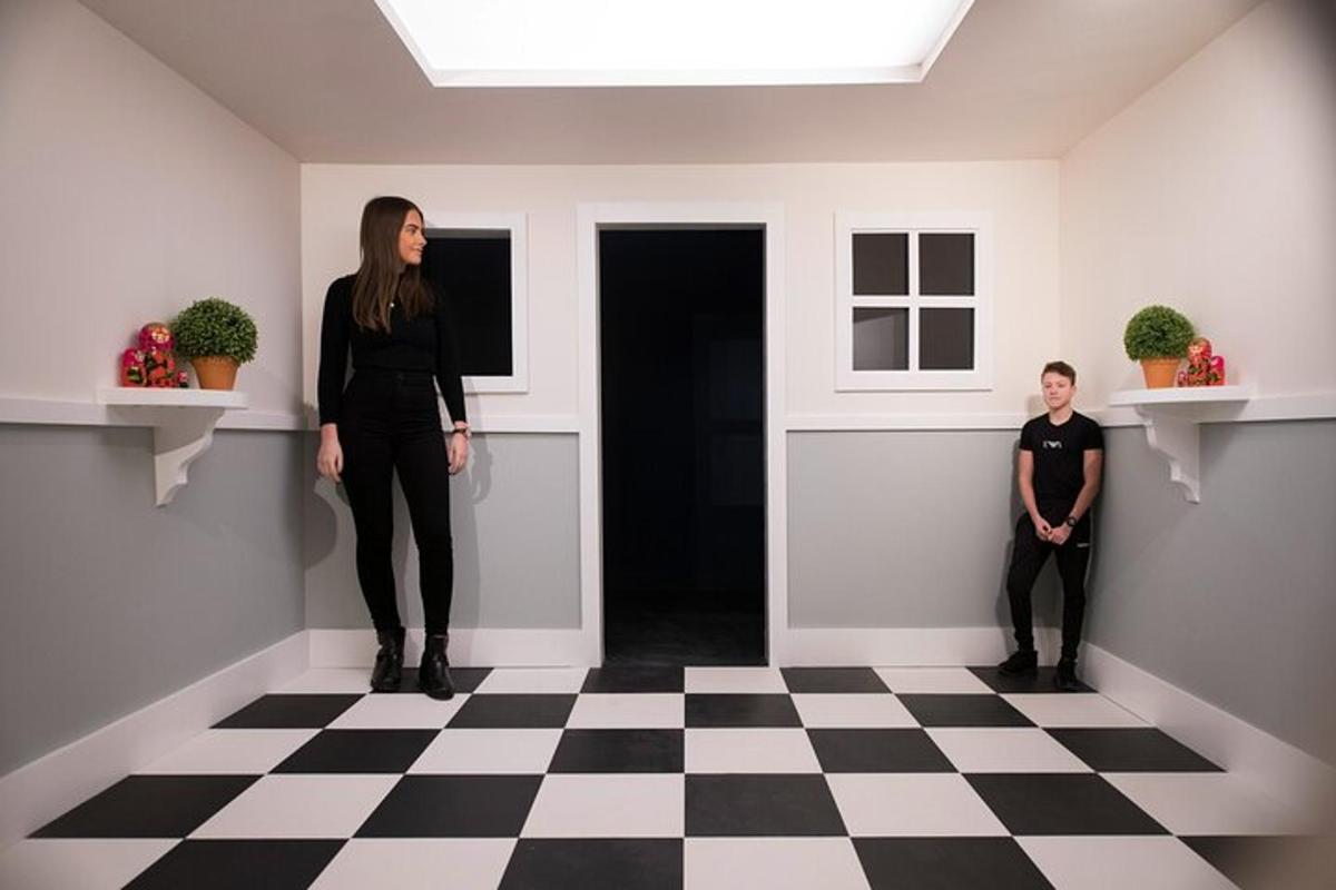 two women standing in a room with a checkered floor