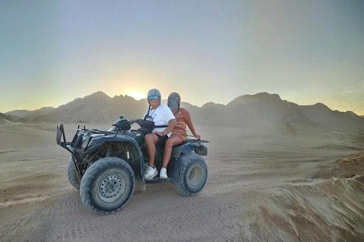 un home i una dona muntant un quad al desert