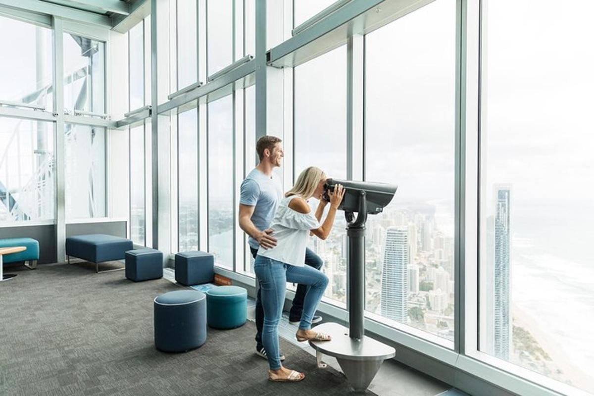 a man and woman standing in a room with a telescope