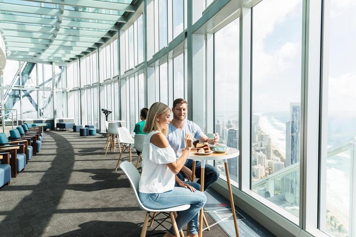 a man and woman sitting at a table in a building with windows