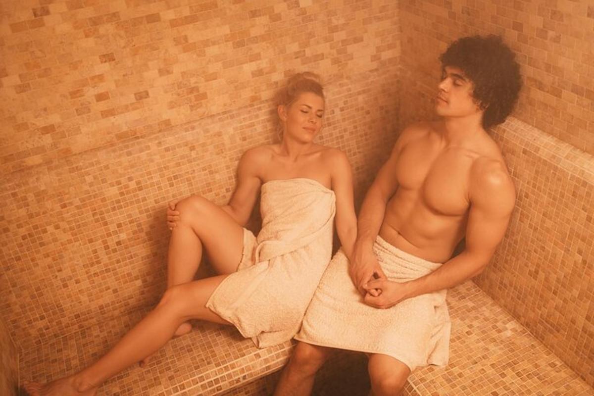 duas mulheres de toalha sentadas em um muro