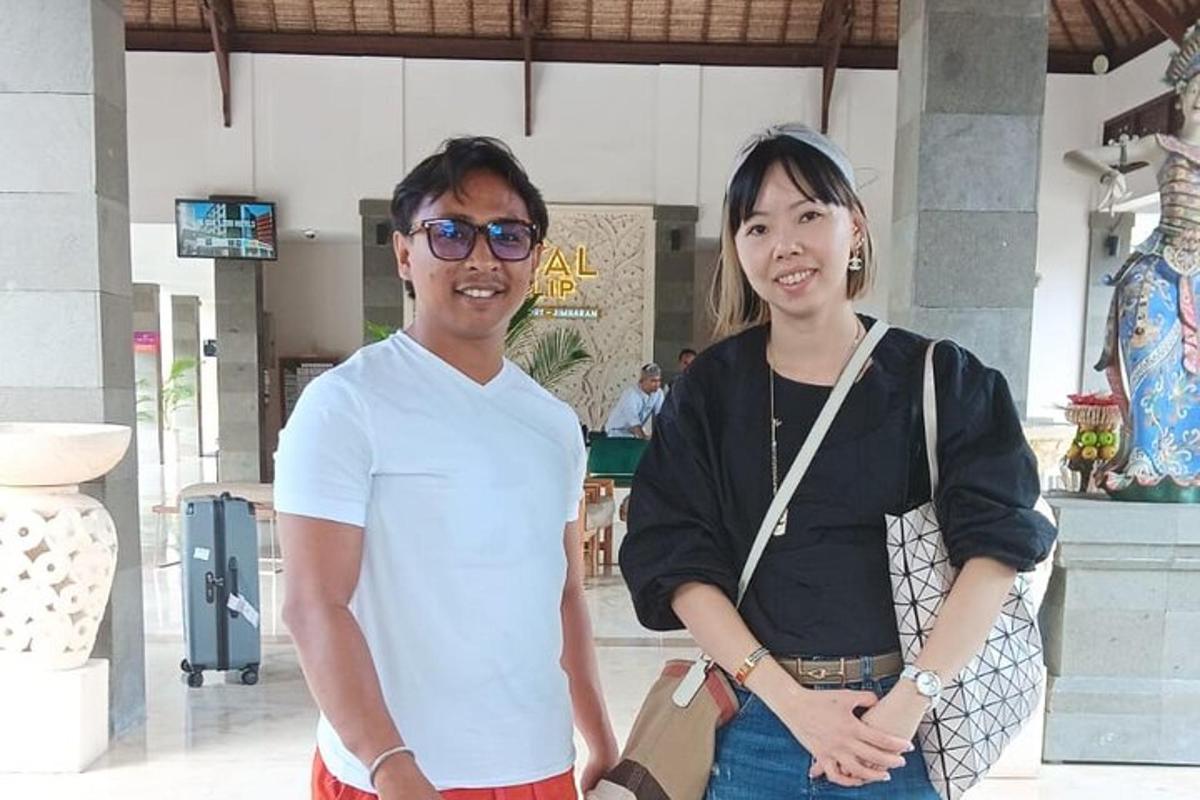 seorang lelaki dan seorang wanita berdiri di hadapan sebuah bangunan