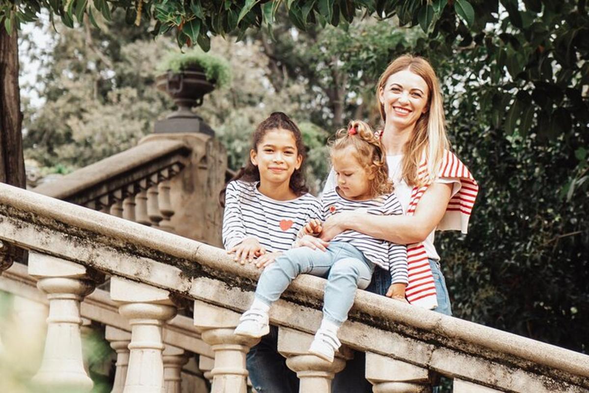 a woman and two children sitting on a railing