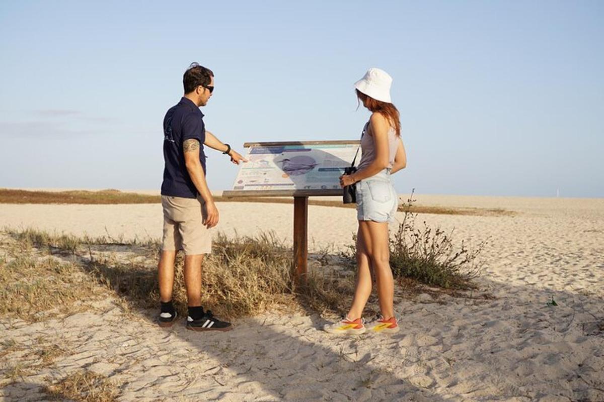 un uomo e una donna in piedi accanto a un tavolo sulla spiaggia