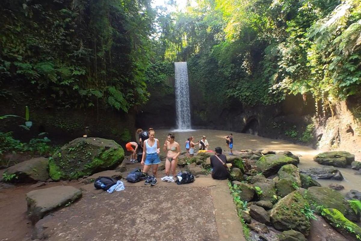 a group of people standing in front of a waterfall