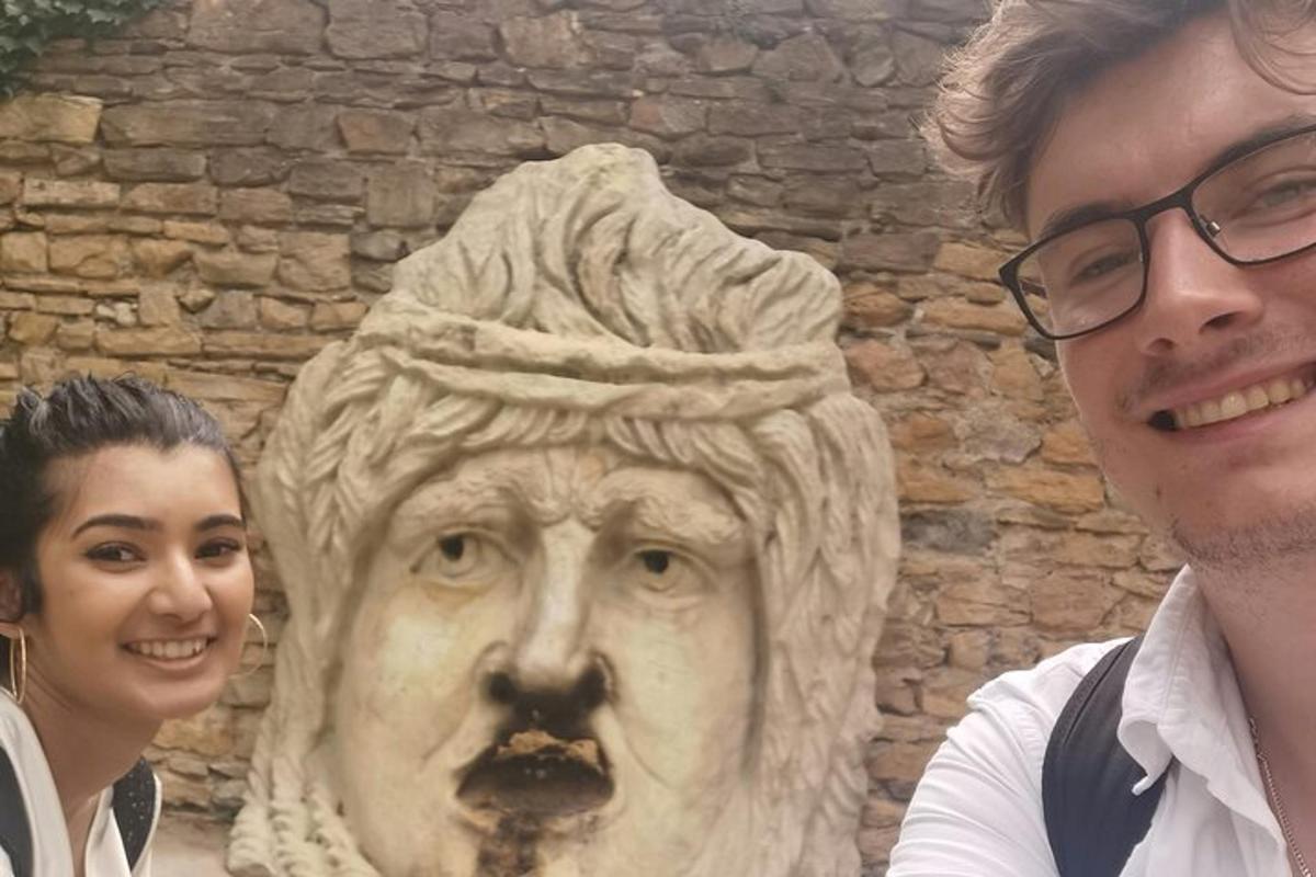 muž a žena stojící vedle sochy