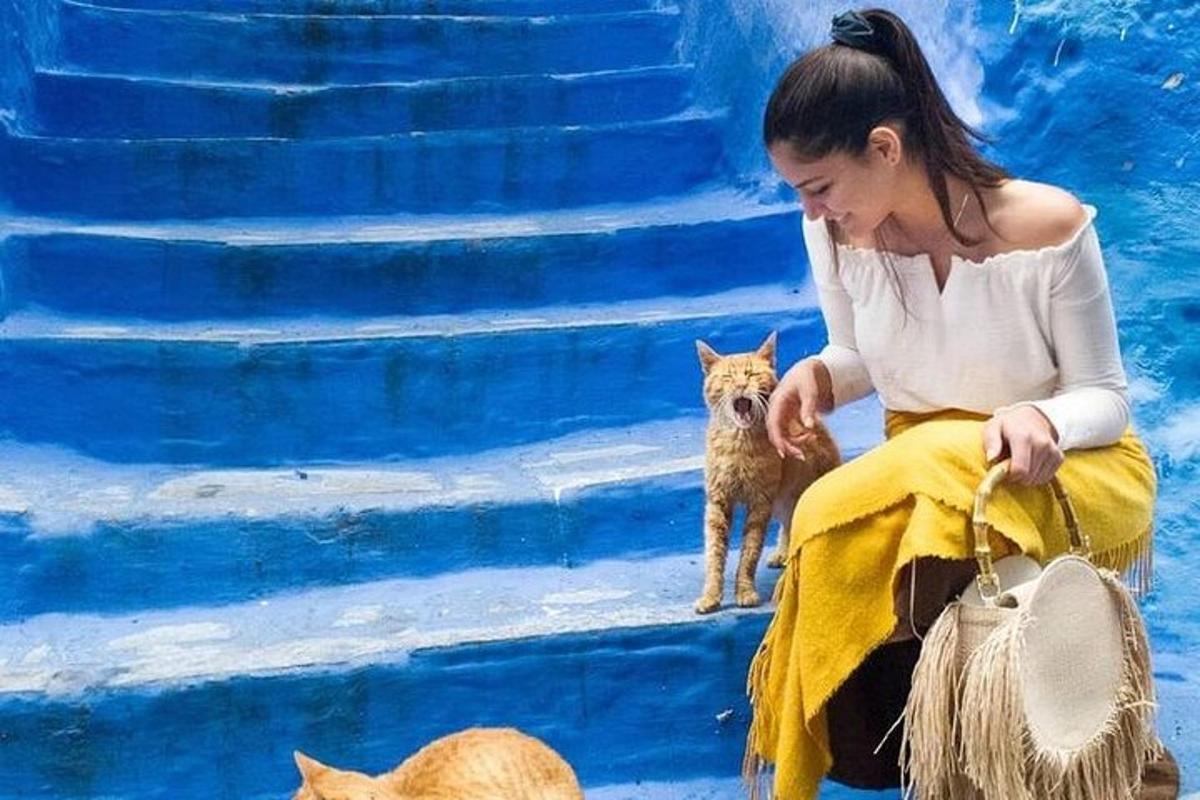 a woman sitting on the steps with a small dog