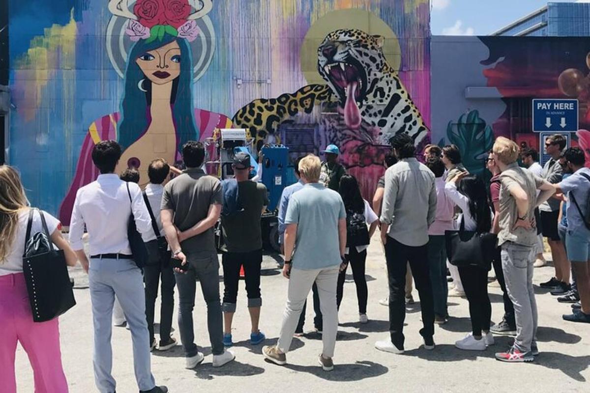 a group of people standing in front of a mural