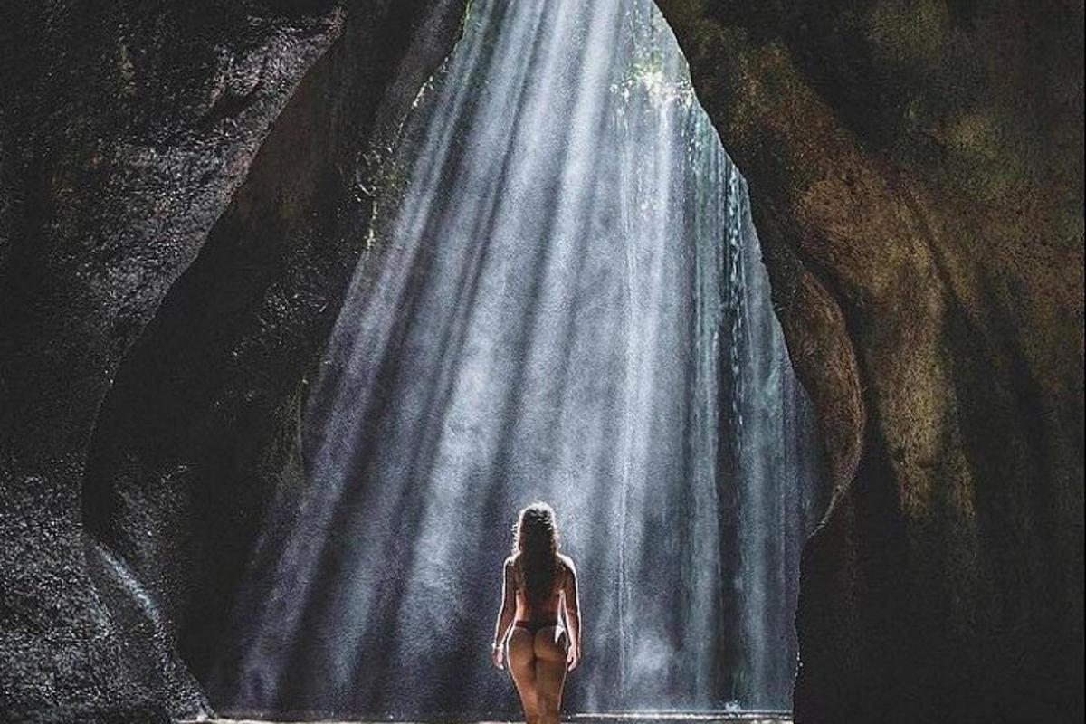una donna è in piedi davanti a una cascata