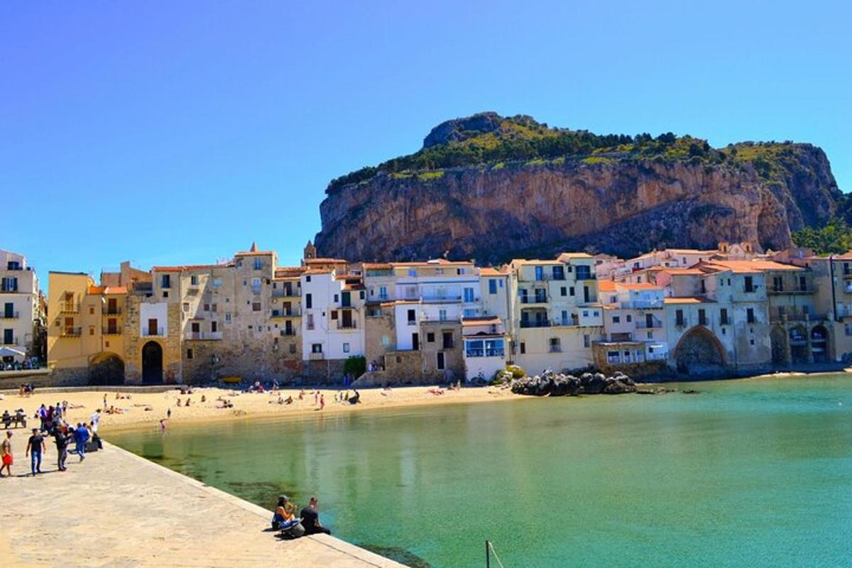 un gruppo di persone su una spiaggia con un gruppo di edifici