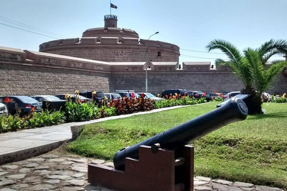 un cannone davanti a un edificio con un parcheggio