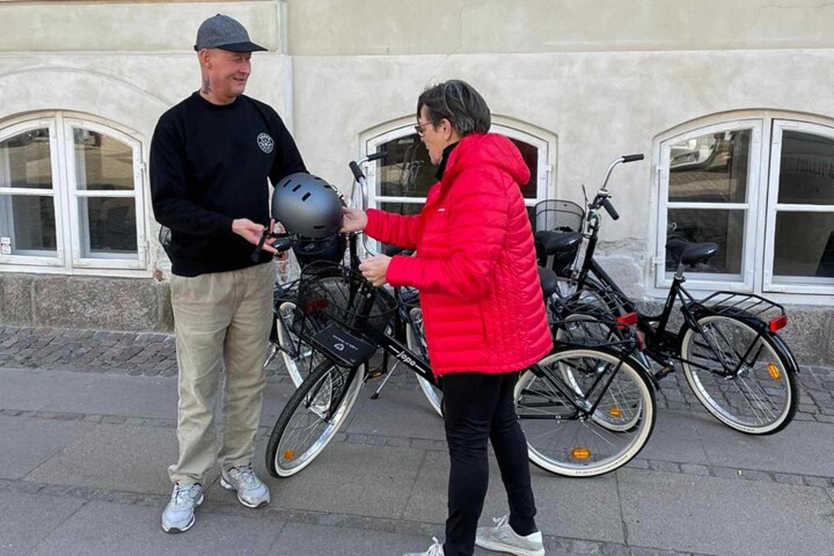 kona í rauðum jakka með hjálm í höndunum