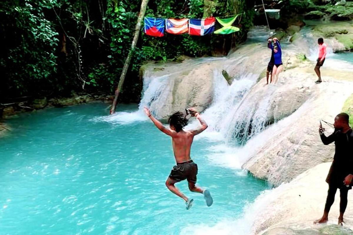 Un hombre saltando de una cascada a un río.