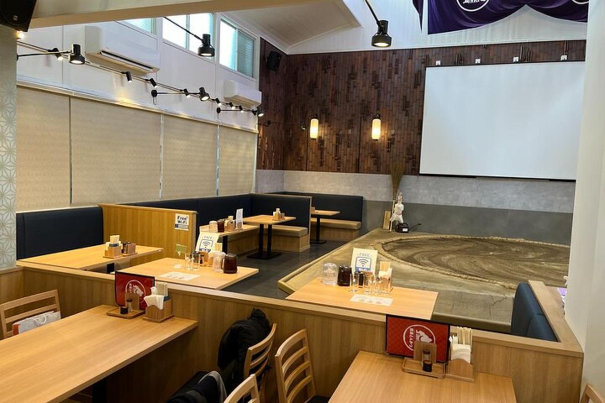 um restaurante com mesas e cadeiras e uma tela de projeção