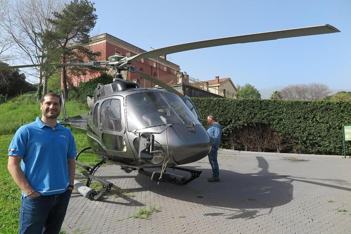 Dva moška stojita pred helikopterjem