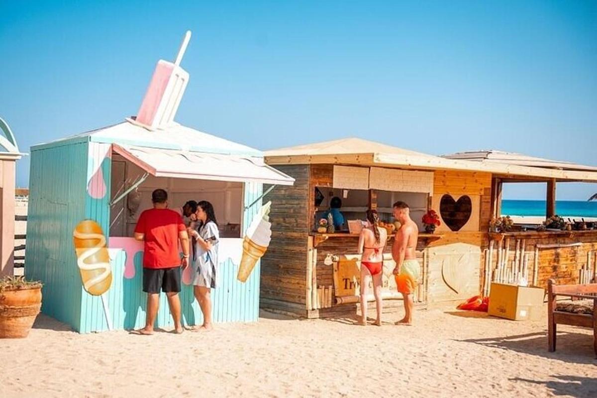 hópur fólks stendur fyrir utan strandskála