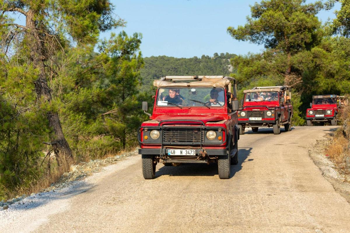 μια ομάδα φορτηγών που οδηγούν σε έναν χωματόδρομο