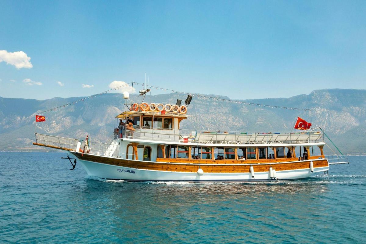 μια βάρκα στο νερό με βουνά στο φόντο