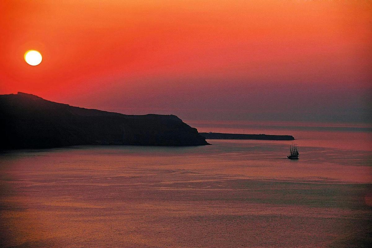 Západ slunce nad oceánem s lodí ve vodě
