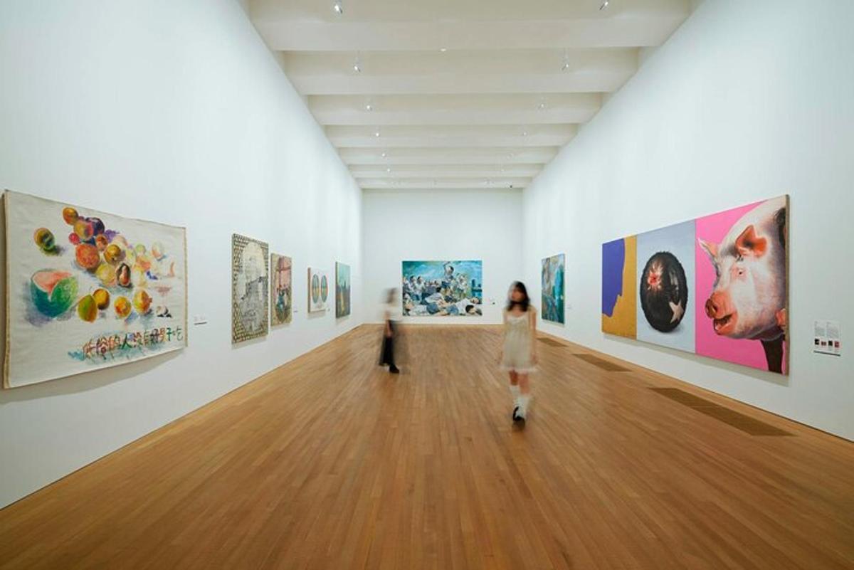 ženska, ki se sprehaja skozi umetniško galerijo s slikami