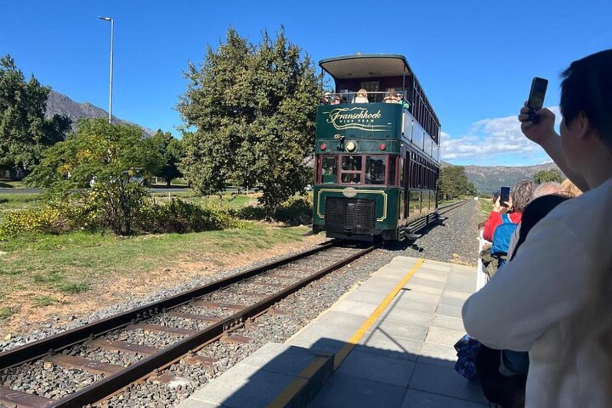 una persona tomando una fotografía de un tren verde