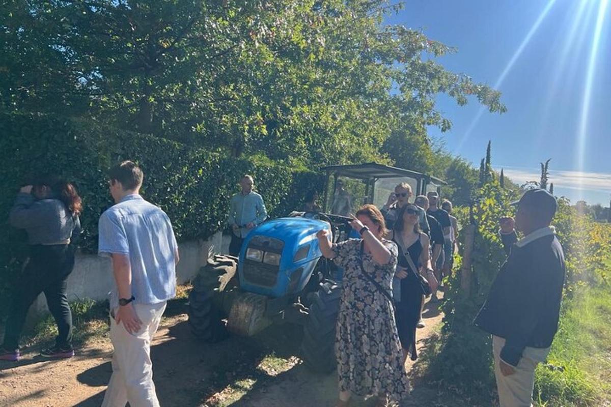 Un grupo de personas de pie delante de un tractor.