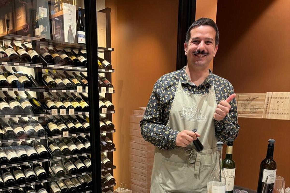a man in an apron holding a bottle of wine