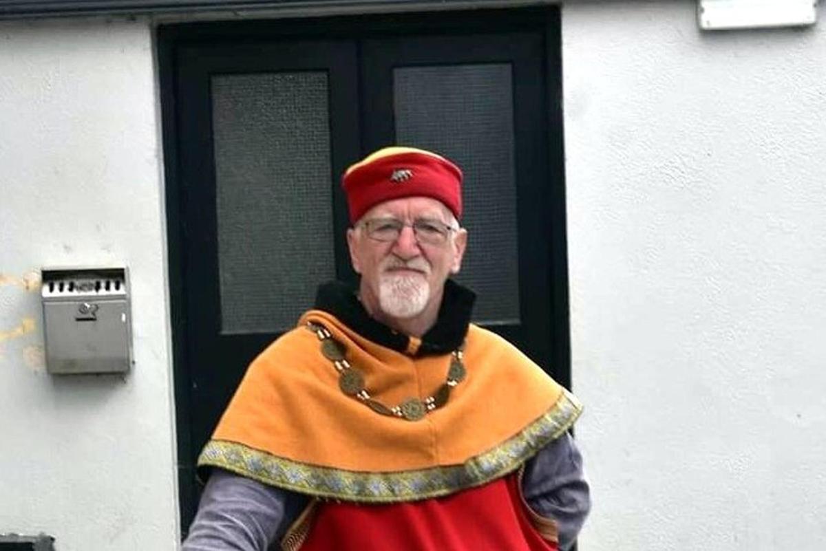 an older man dressed in a costume in front of a door
