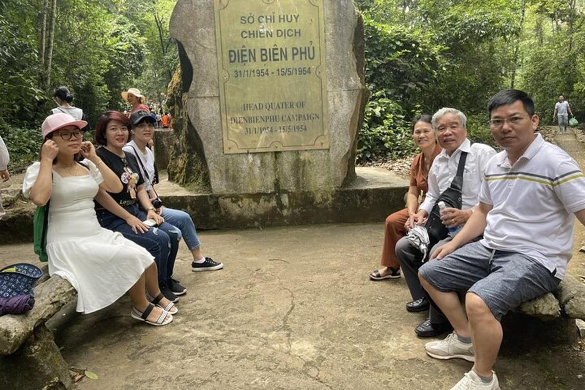 a group of people sitting in front of a grave