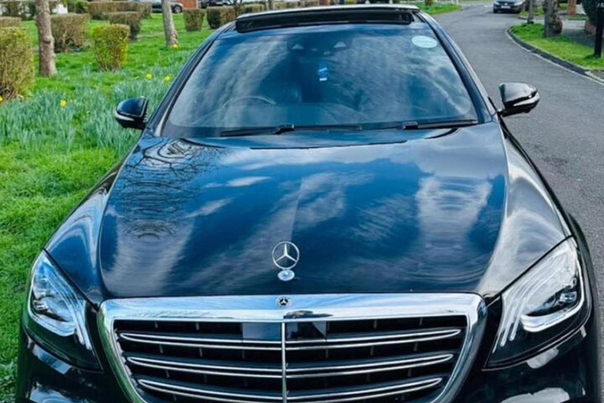 un'auto Mercedes Benz parcheggiata sul ciglio della strada