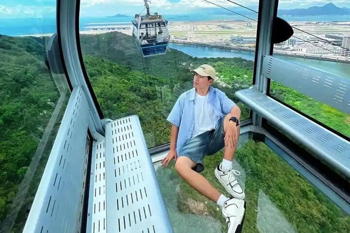 un uomo seduto sul bordo di una gondola che vola nel cielo