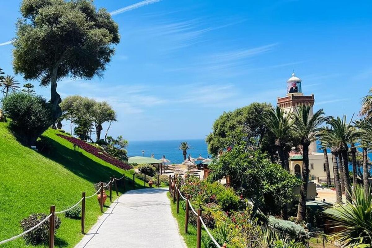 uma passarela por um parque com um prédio e o oceano