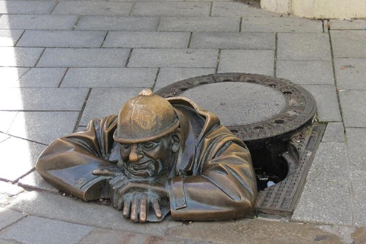 una statua in bronzo di un uomo sdraiato a terra