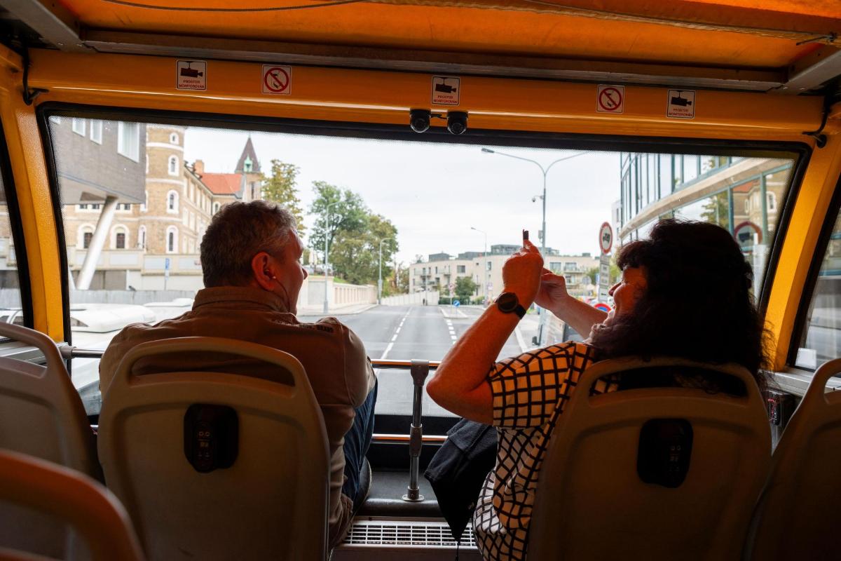 muž a žena sedící v autobuse a dívající se z okna
