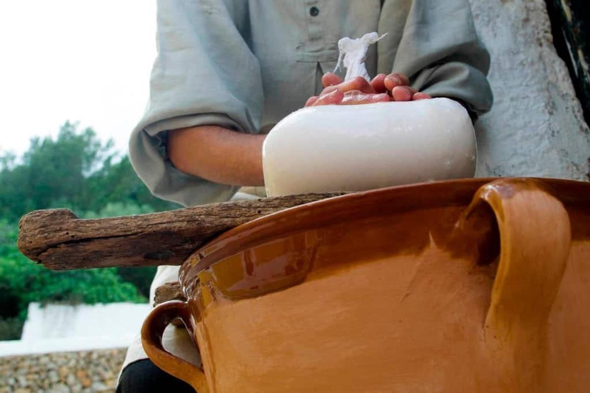 a person holding a candle on top of a chair