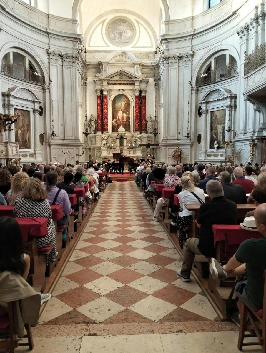 velký dav lidí sedících ve velké katedrále