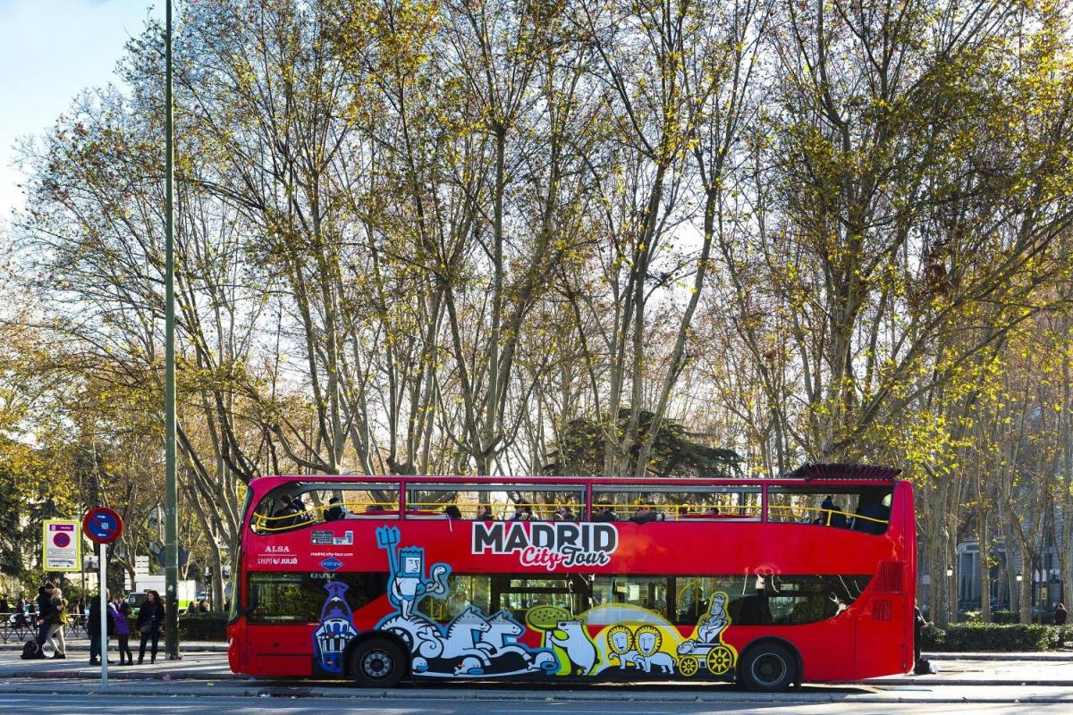 a red double decker bus on a city street