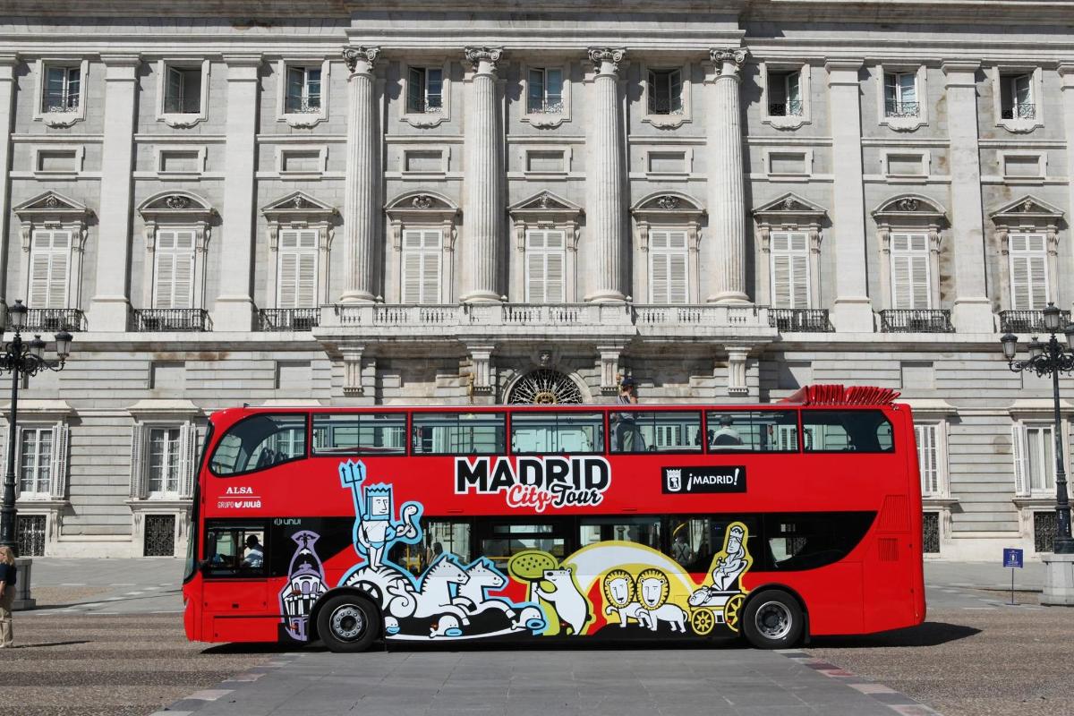 a red double decker bus parked in front of a building