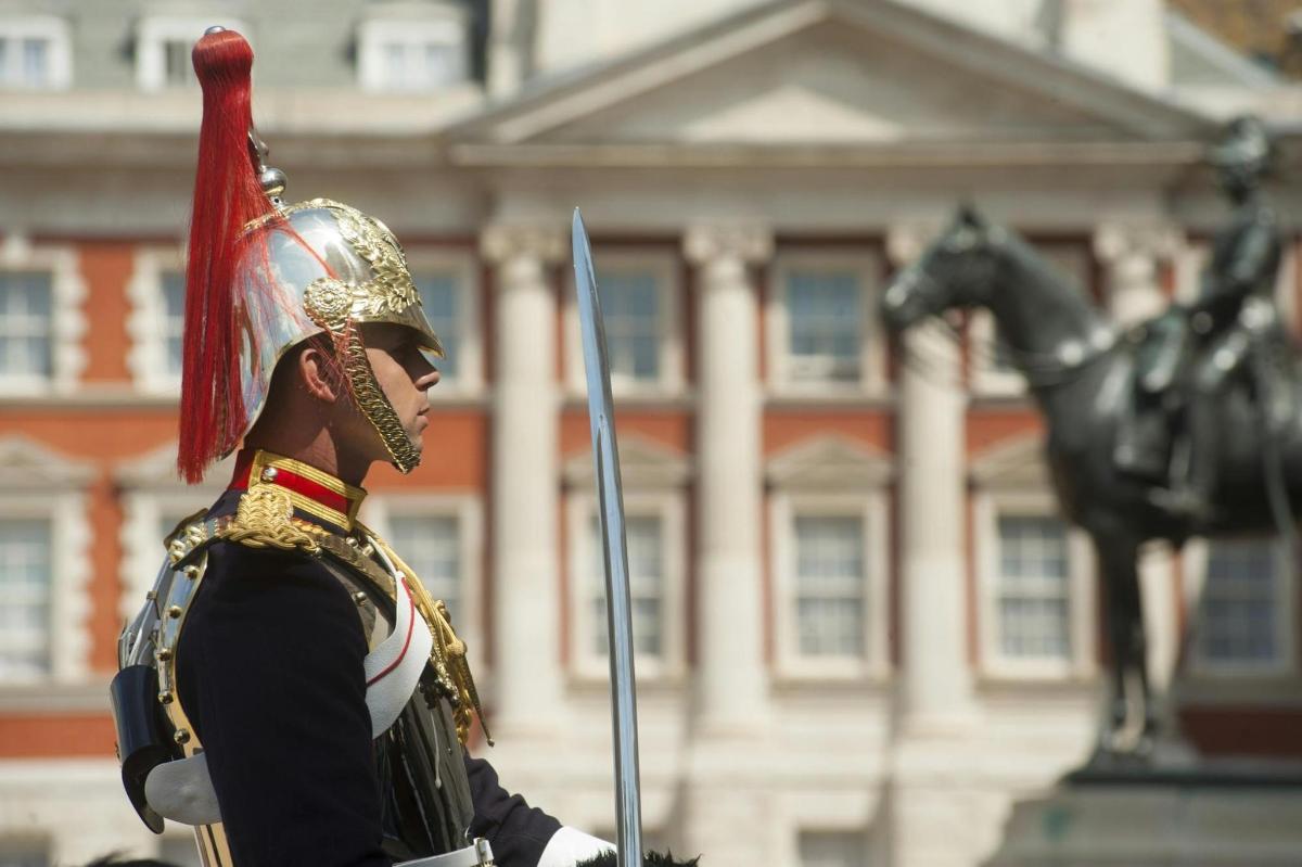 muž ve vojenské uniformě stojící před budovou