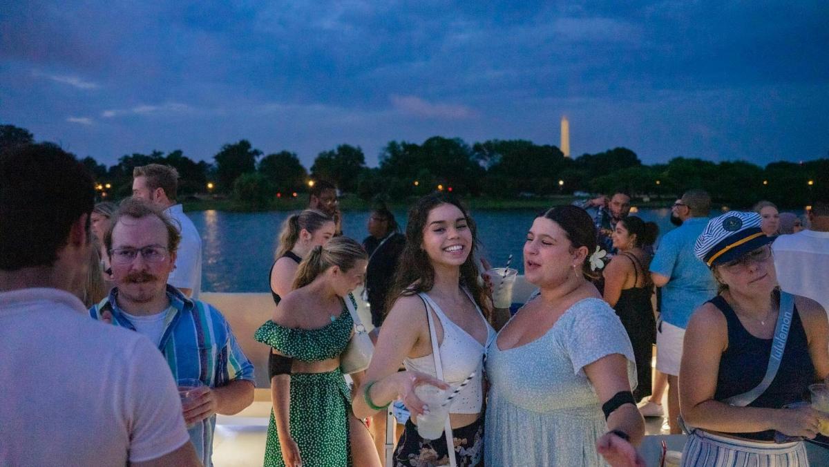 a group of people standing on a boat at a party