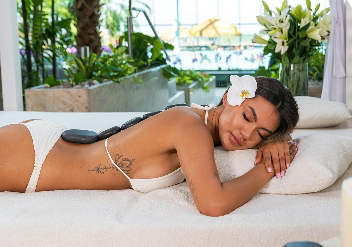 Una mujer en bikini blanco acostada en una cama