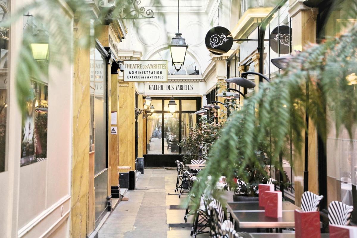 egy sikátor asztalokkal és székekkel egy épületben
