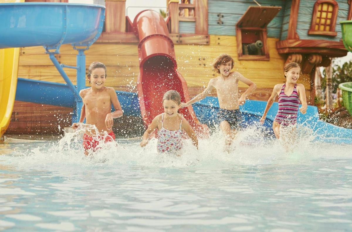 un gruppo di bambini che giocano in un parco acquatico